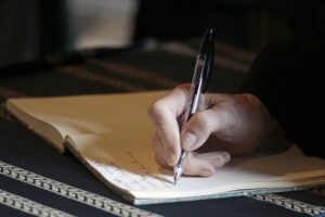 Starsza osoba pisząca w dzienniku - prawo spadkowe i testamenty