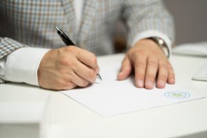 Mężczyzna podpisujący dokumenty - prawo spadkowe i testamenty